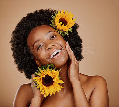 Buy stock photo Portrait, skincare and sunflower with a model black woman in studio on a brown background for cosmetics. Face, beauty or natural and a happy young female person with a flower in her afro hair