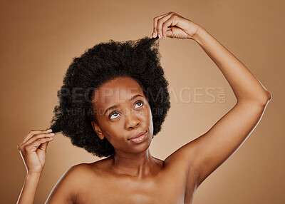 Buy stock photo Thinking, black woman and hair care for afro, health and wellness in studio isolated on a brown background. Growth, hairstyle and African model with natural cosmetics after salon treatment for beauty