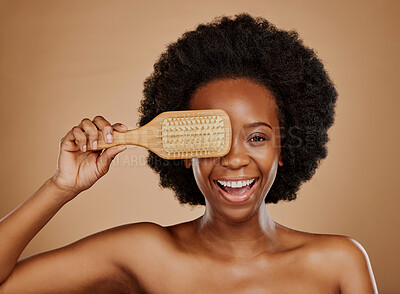 Buy stock photo Portrait, hair and brush with a model black woman in studio on brown background for beauty or cosmetics. Aesthetic, afro and haircare with a happy young female person looking excited for natural care