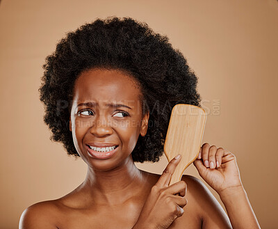 Buy stock photo Black woman, hair problem and pain with brush in studio, brown background and dry tangled afro. Beauty, unhappy female model and comb knot in hairstyle with anxiety, stress or damage to curly texture