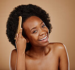 Black woman, portrait and hairstyle brush in studio, brown background and grooming of curly texture. Natural beauty, happy face and young african female model with comb tools for aesthetic hair care