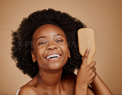 Buy stock photo Happy black woman, brush and hair care in studio, brown background and treatment of curly texture. Natural beauty, smile and face of young african female model comb clean, healthy or afro hairstyle