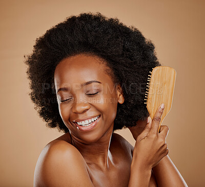 Buy stock photo Happy black woman, afro and brush hair in studio, brown background and treatment of curly texture. Natural beauty, smile and face of young african female model with comb, hairstyle or aesthetic tools