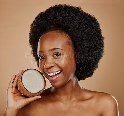 Buy stock photo Portrait, skin and coconut with a model black woman in studio on a brown background for natural treatment. Beauty, skincare and cosmetics with a happy young female person holding fruit for oil