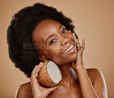 Buy stock photo Portrait, skincare and coconut with a model black woman in studio on a brown background for natural treatment. Beauty, skin and cosmetics with a happy young female person holding fruit for oil