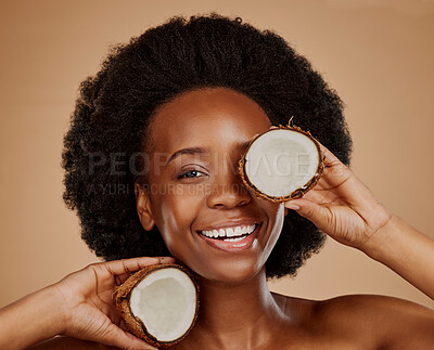 Buy stock photo Portrait, beauty and coconut with a model black woman in studio on a brown background for natural treatment. Smile, skincare and cosmetics with a happy young female person holding fruit for oil