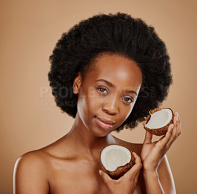 Buy stock photo Portrait, facial and coconut with a model black woman in studio on a brown background for natural treatment. Face, skincare or luxury beauty cosmetics with a young female person holding fruit for oil
