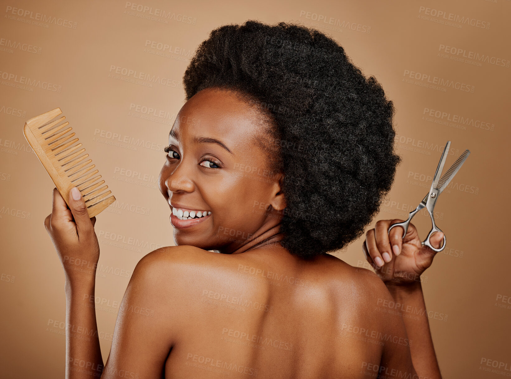 Buy stock photo Portrait, back and a black woman with a comb and scissors in studio on a brown background for a haircut. Smile, afro and haircare with a happy young female person looking excited at the salon