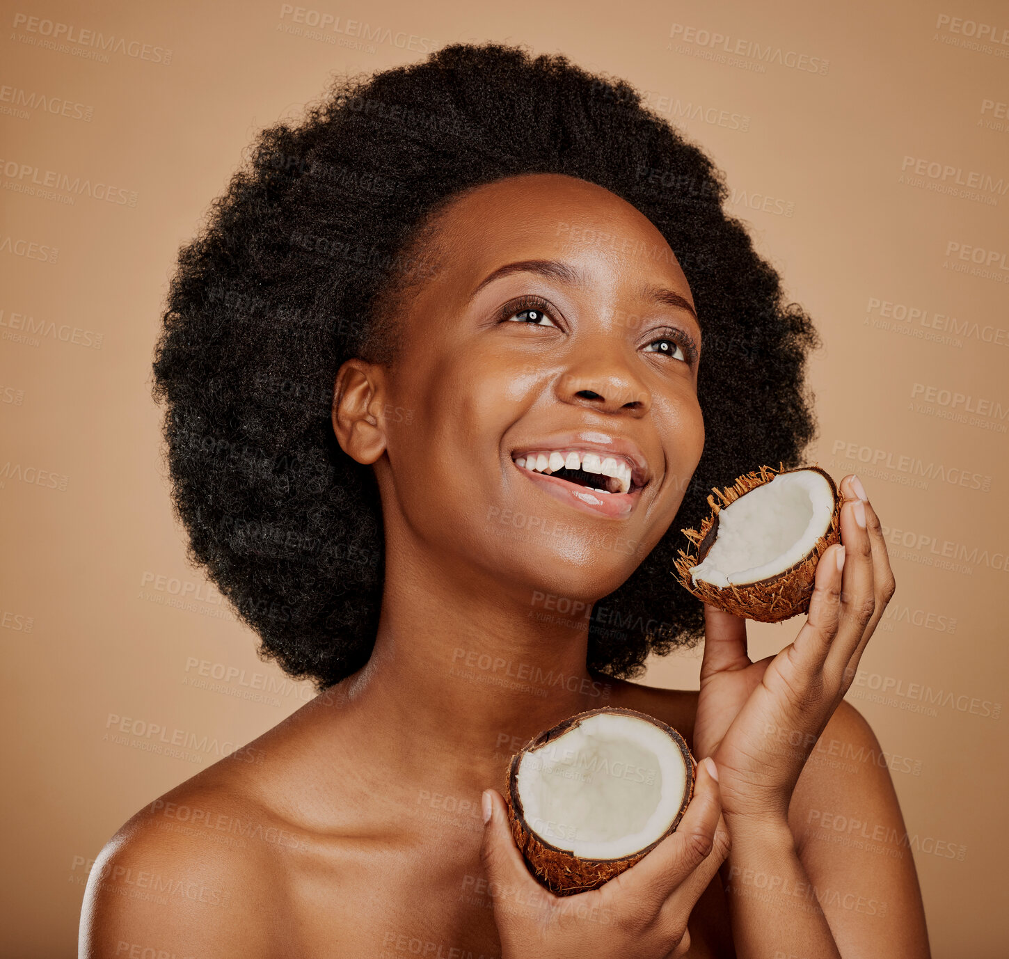Buy stock photo Beauty, skincare and coconut with a model black woman in studio on a brown background for natural treatment. Thinking, skin and cosmetics with a happy young female person holding fruit for oil
