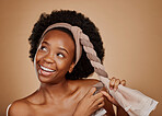 Happy, afro or black woman with headband thinking of change or beauty in studio on brown background. Tie, smile or thoughtful African girl model excited by haircare idea, scarf hairstyle or self love