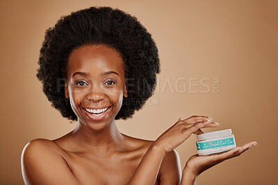 Portrait, hair and keratin product with a black woman in studio on a brown background for cosmetics. Face, smile and haircare treatment in the palm of a happy female model for natural afro hairstyle