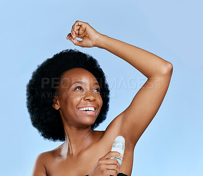 Buy stock photo Happy, deodorant and armpit of black woman for wellness in studio isolated on a blue background. Smile, underarm and African model with roll on product for cosmetics, thinking and healthy fresh scent
