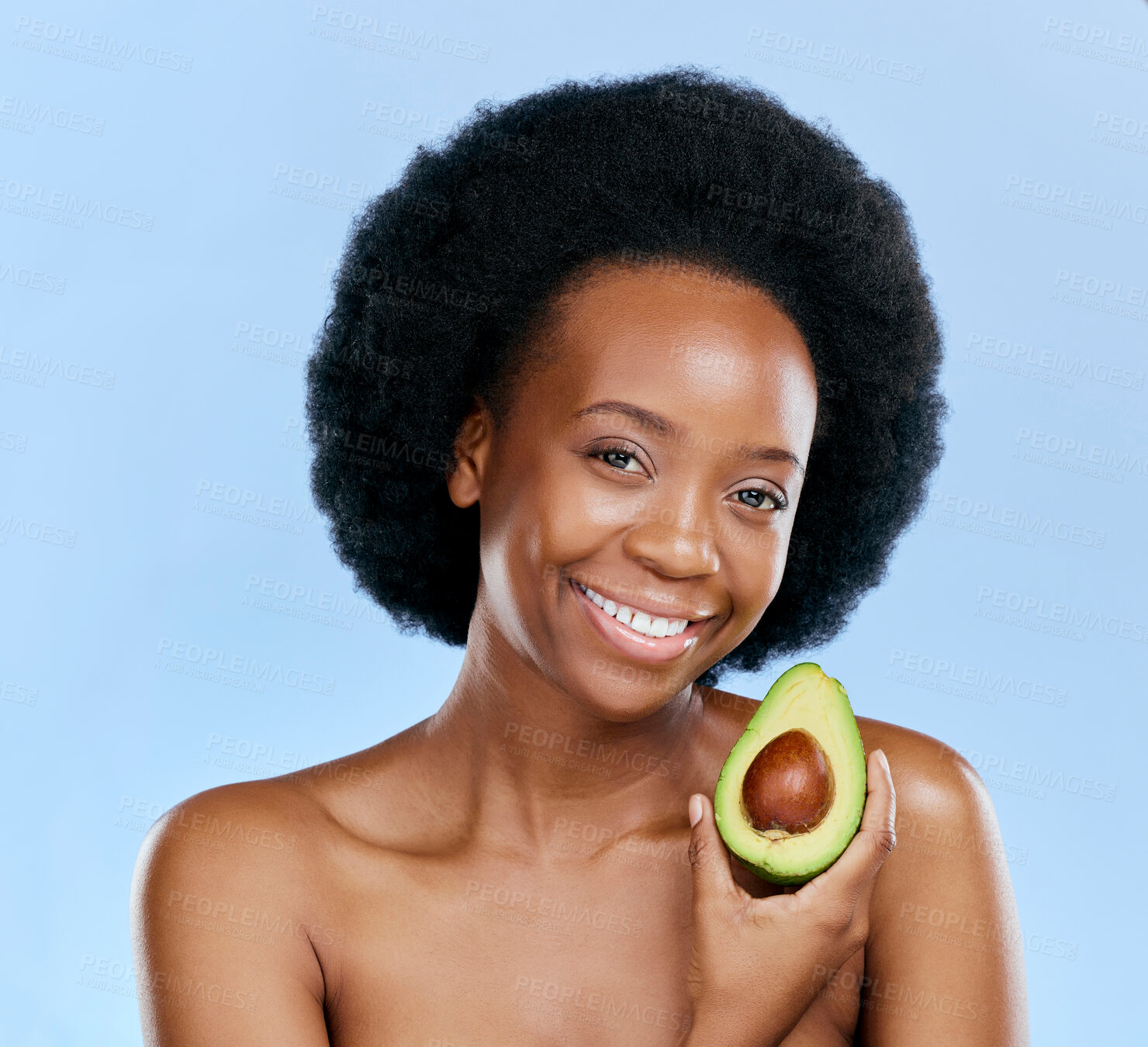 Buy stock photo Portrait, beauty and avocado with a black woman on a blue background in studio to detox for wellness. Skincare, smile and face with a happy young female model holding a fruit for antioxidants