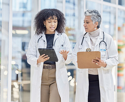 Buy stock photo Team, tablet and documents with woman doctors walking in a hospital for insurance or healthcare discussion. Collaboration, trust and consulting with female medicine professionals talking in a clinic