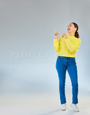 Buy stock photo Space, happy and presentation with woman and pointing in studio for show, advertising and idea. Announcement, promotion and deal with person on grey background for opportunity, offer and news mockup