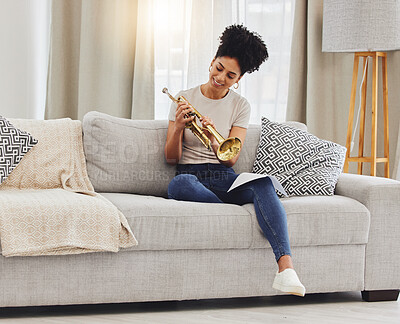 Buy stock photo Happy, woman and learning notes on trumpet in home for music, practice and classic jazz song. Young female person, musician and brass horn instrument on sofa, living room and hobby of musical talent