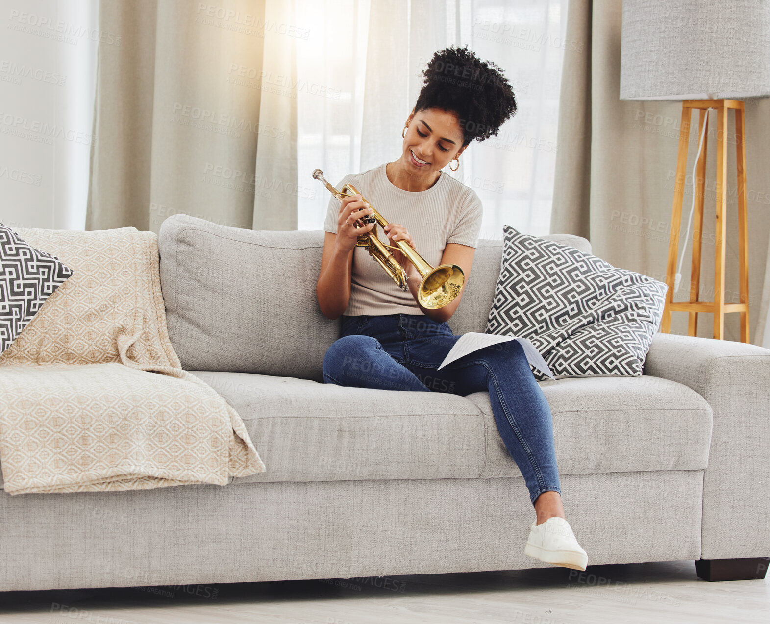Buy stock photo Happy, woman and learning notes on trumpet in home for music, practice and classic jazz song. Young female person, musician and brass horn instrument on sofa, living room and hobby of musical talent