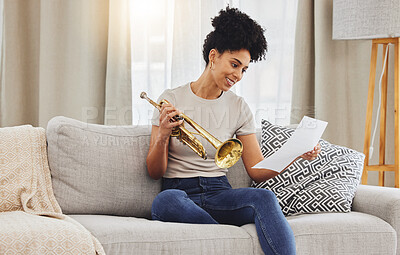 Buy stock photo Woman, music sheet and trumpet in home for learning, practice and classic jazz song. Happy young female person reading paper notes for brass horn instrument, hobby and musical talent in living room