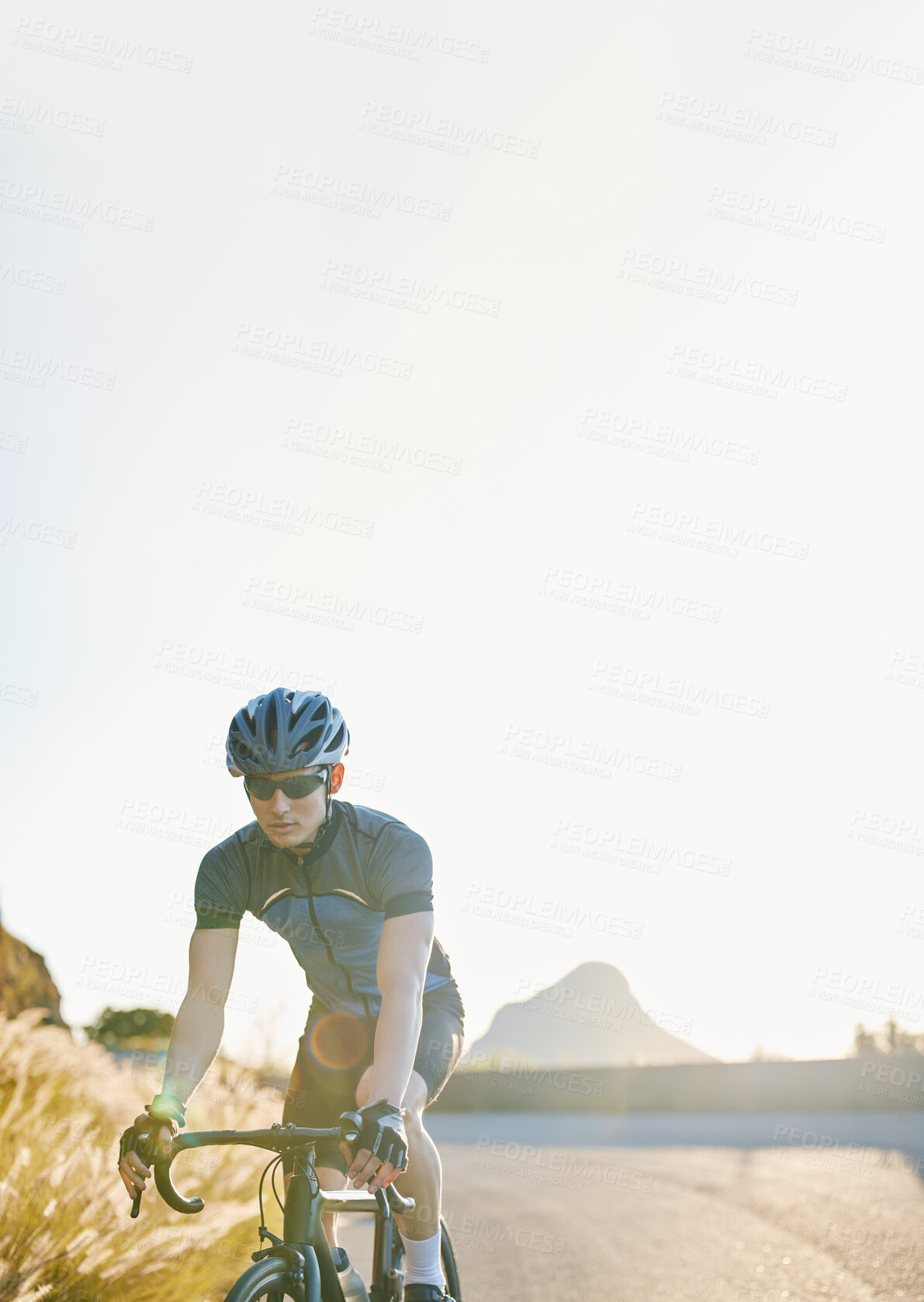 Buy stock photo Training, bike and cycling with a sports man on a road through the mountain for cardio or endurance. Exercise, workout or fitness with a male cyclist riding his bicycle on an asphalt street in nature