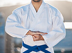 Karate, fitness and respect with a sports man in gi, training in the city on a blurred background. Exercise, discipline or fight with a male athlete during a self defense workout for health closeup