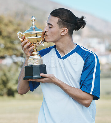 Buy stock photo Soccer player, celebrate and competition with trophy in the outdoor with a kiss after win. Sports person, champion and football with award on a field with happiness for winning a game as achievement.