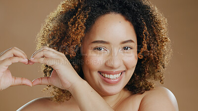 Buy stock photo Portrait of happy woman, heart hands or natural beauty dermatology for wellness in studio with smile. Skin glow, skincare or proud biracial female person with self love gesture on brown background