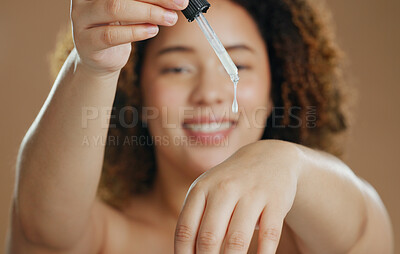 Buy stock photo Skincare, product or hands of woman with serum in studio for a natural glow, wellness or cosmetic routine. Bottle closeup, beauty or model with facial oil in dermatology treatment on brown background