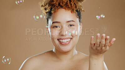 Buy stock photo Woman in portrait, bubbles and natural beauty, happy with cosmetics for skincare and glow on brown background. Dermatology, wellness for skin and liquid soap with self care and anti aging in studio