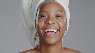 Buy stock photo Portrait, cream and laughing with a happy black woman in studio on a gray background for natural wellness. Face, funny and lotion with a happy young model closeup to apply treatment to her skin