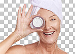 Portrait of a happy smiling caucasian woman using moisturiser against purple copyspace background. Mature model doing her routine skin and hair care in a studio
