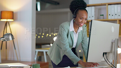 Buy stock photo African woman, call center and typing in office with microphone, night or telemarketing with contact us. Consultant, crm and tech support agent with customer service, pc and reading at help desk