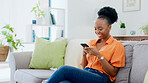 Phone, happy and black woman on a sofa typing a text message while relaxing in her living room. Happiness, smile and African female networking, browsing or scrolling on social media with a cellphone.