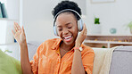 Black woman dancing on couch with headphones, music streaming and mental health, wellness and happy energy. African person dance on sofa, listening to audio technology and singing hip hop audio