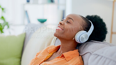 Buy stock photo Calm woman, music and headphones in home for listening to audio, radio and hearing podcast on sofa. Happy african person relax for streaming sound, multimedia and peaceful subscription in living room