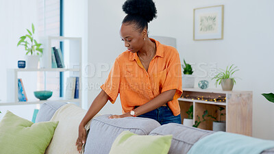 Buy stock photo Woman, cleaning and housekeeping in living room, pillow and tidy and organized or neat on furniture. Black person, domestic and chores for hygiene and sanitary cleanup for fresh home and apartment