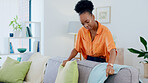 Cleaning, pillow and relax with black woman on sofa for housework, chores and domestic service. Hygiene, decoration and cleaner with girl and furniture in living room at home for sanitary and lounge