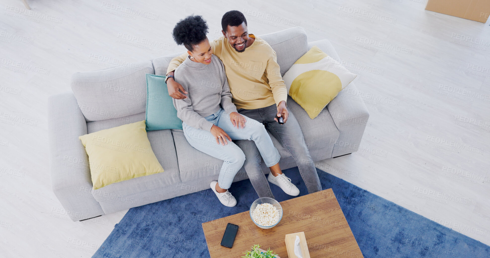 Buy stock photo Black couple, top view and couch in living room, tv and relax with popcorn, movies and funny comedy. Man, woman and hug for bonding together, streaming and happy in lounge, couch and remote control