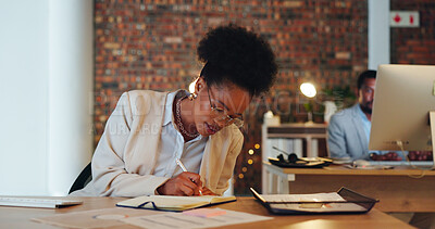 Buy stock photo Business woman, writing notes and planning in office for startup goals, administration and schedule or reminder at night. African employee or writer in workspace with notebook, ideas or brainstorming