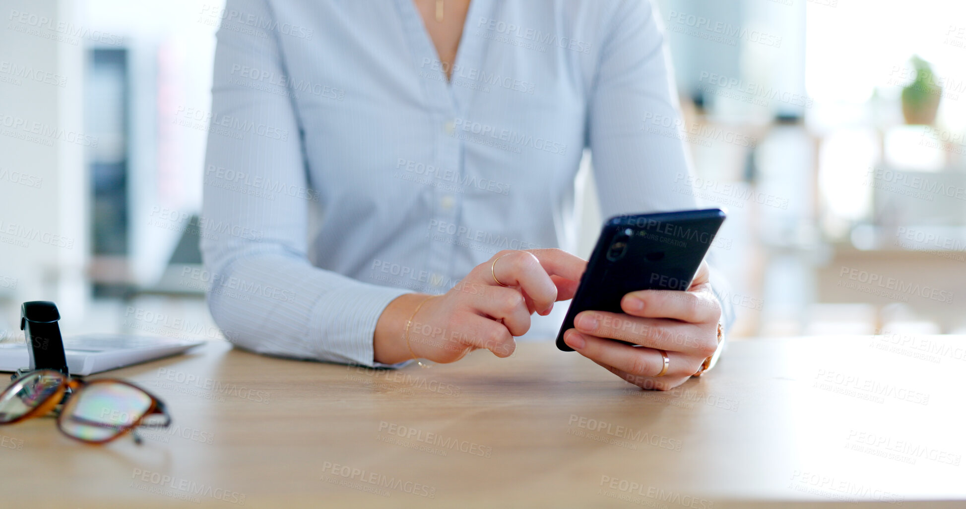 Buy stock photo Phone, hands typing at desk and closeup on social media, networking or writing email in office. Business woman on mobile app at table, digital communication and consultant scroll for internet search