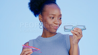 Buy stock photo Black woman, sunglasses choice and vision with smile in studio, protection and accessory isolated on blue background. Decision, funky style or retro with fashion, safety and shades for eye care