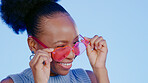 Black woman, sunglasses and face in studio with wink, choice or happiness for fashion by blue background. Gen z girl, heart glasses or shades with choice, portrait or happy for accessory by backdrop