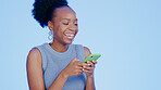 Black woman, texting and phone in studio with smile, meme or social network app for fashion by blue background. Gen z girl, smartphone or blog for funny video, communication and web chat by backdrop