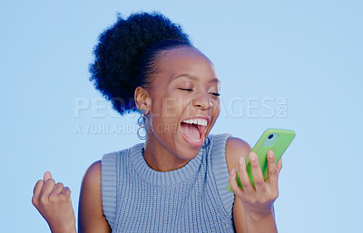 Buy stock photo Celebration. phone and young black woman in a studio with winning, achievement or success. Happy, smile and African female winner cheering with fist pump on cellphone isolated by blue background.