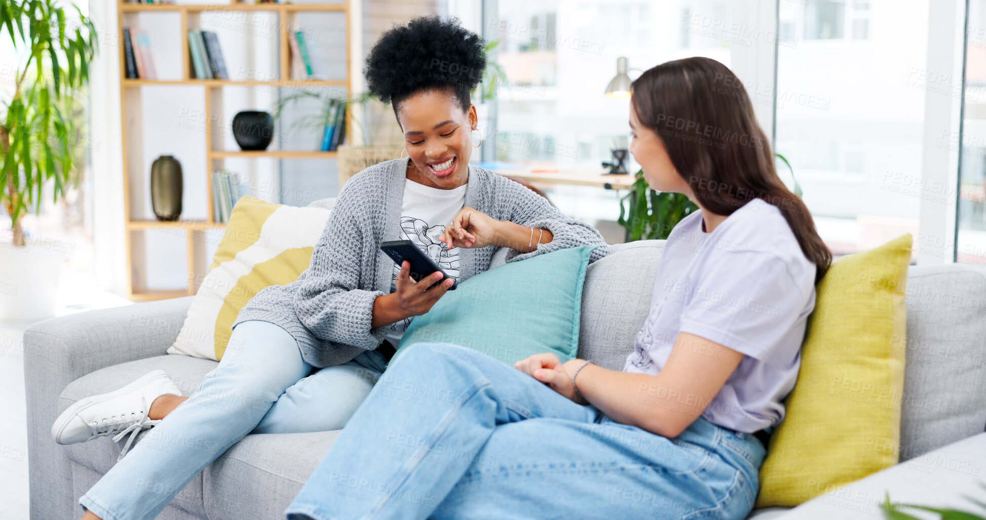 Buy stock photo Phone, conversation and girl friends on a sofa talking, bonding and networking on social media or mobile app. Happy, discussion and young women scroll on cellphone in living room of modern apartment.