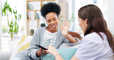 Buy stock photo Phone, talking and girl friends on a sofa bonding and networking on social media or mobile app. Happy, discussion and young women scroll on cellphone together in living room of modern apartment.