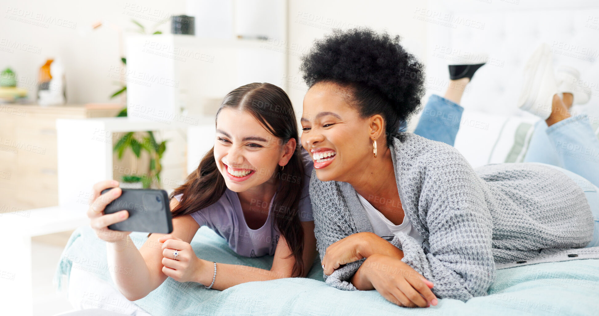 Buy stock photo Happy, selfie and girl friends on a bed for bonding and relaxing together with a phone. Smile, technology and interracial female people taking a picture with cellphone in bedroom of modern apartment.