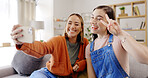 Phone, selfie and friends on a living room sofa taking a profile picture together for social media. Digital, women and girl friend in a home with peace sign posing on a mobile for web app in house