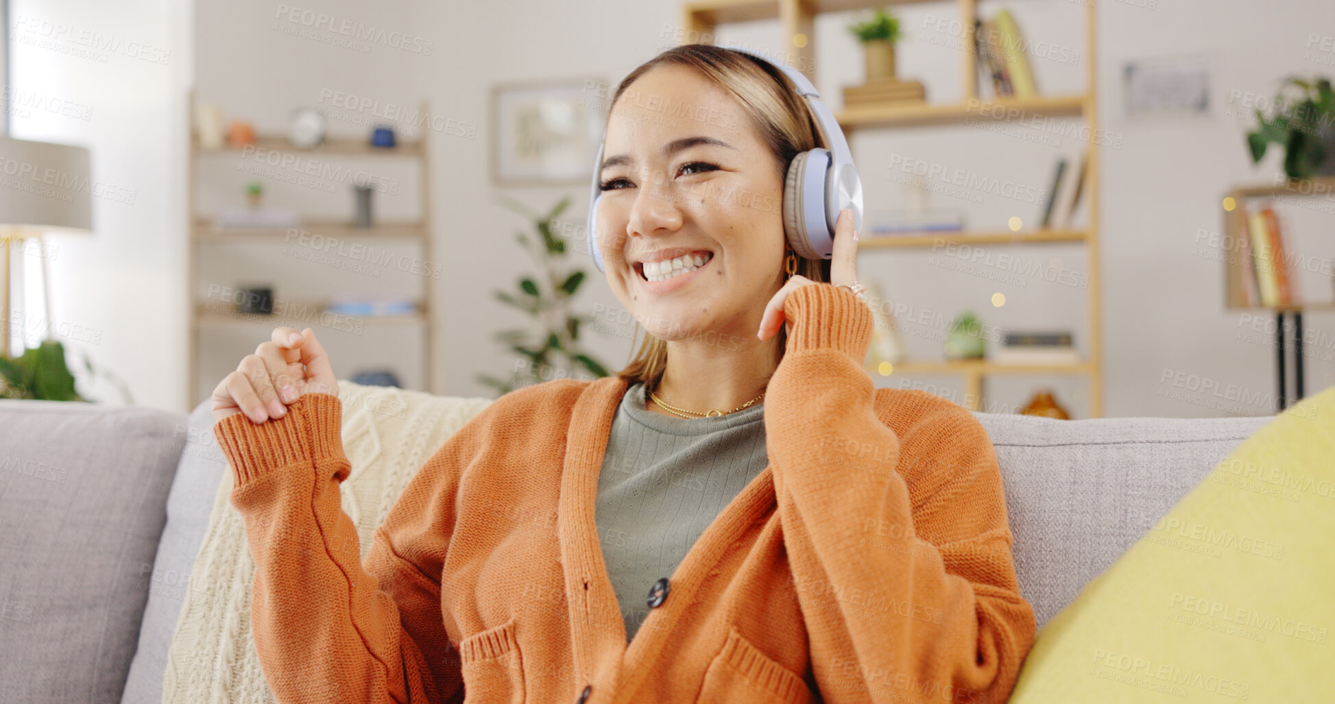 Buy stock photo Dance, music and an asian woman on a sofa in the living room of her home to relax while streaming audio. Smile, freedom and wellness with a young person listening to the radio in her apartment