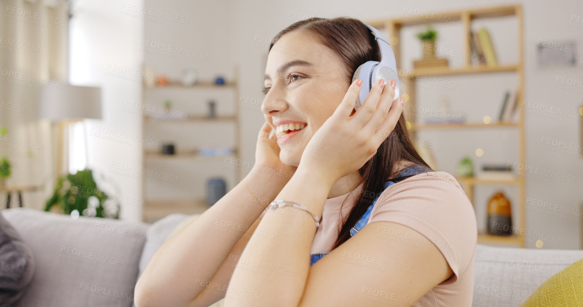 Buy stock photo Freedom, music and a woman on a sofa in the living room of her home to relax while streaming audio. Smile, wellness and a happy young person listening to a radio subscription service in her apartment