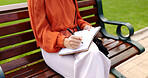 Park, bench and a woman writing in a notebook, diary or journal while outdoor in a garden to relax. Hands, inspiration and journalism with a female writer sitting outside in a natural environment